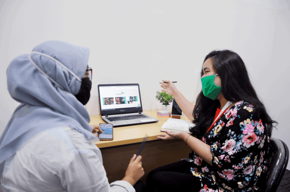 2 Females Employees of Cohub Discussing in Front of a Laptop